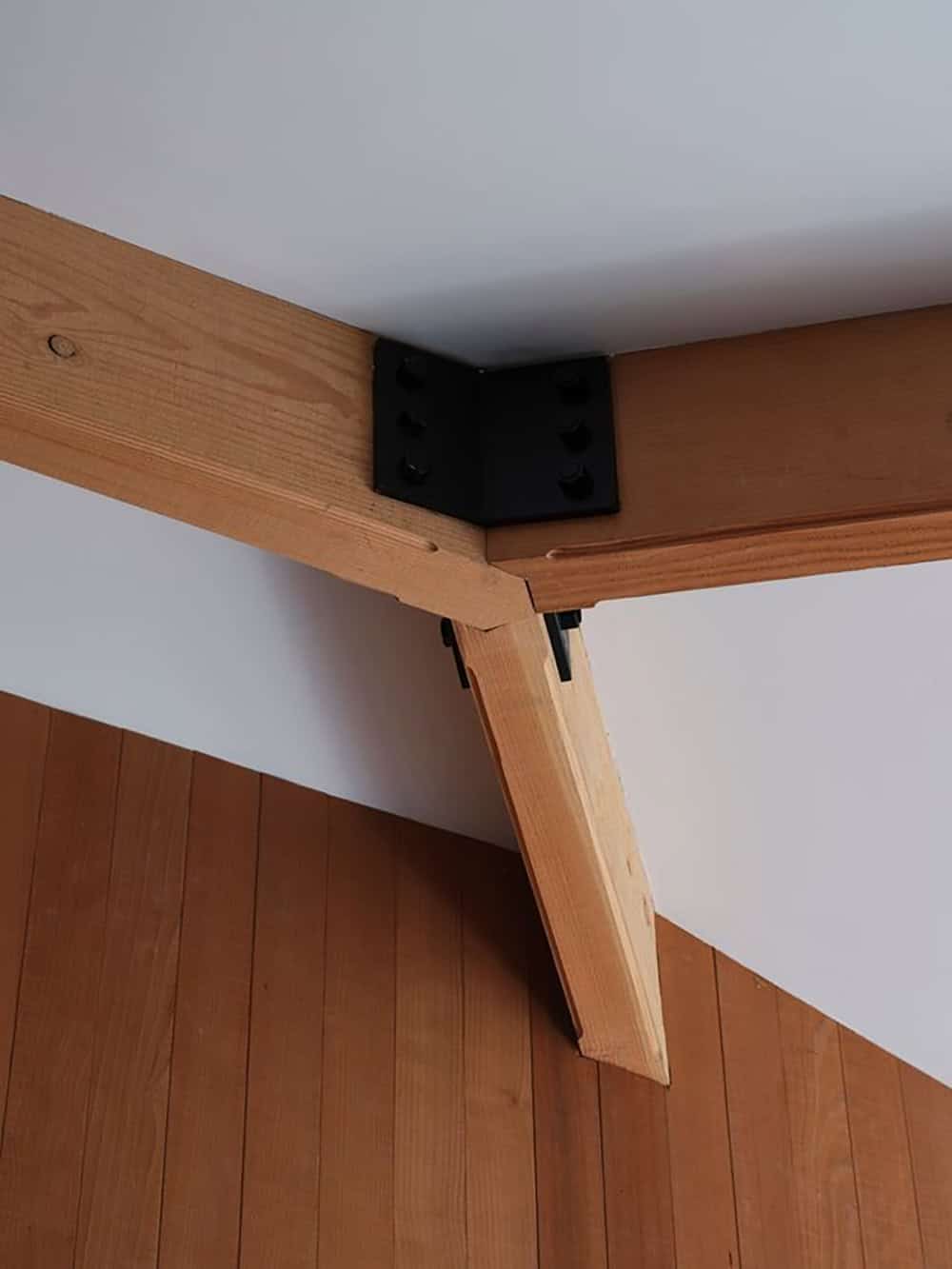 Close-up of custom steel beam connector joining angled roof supports