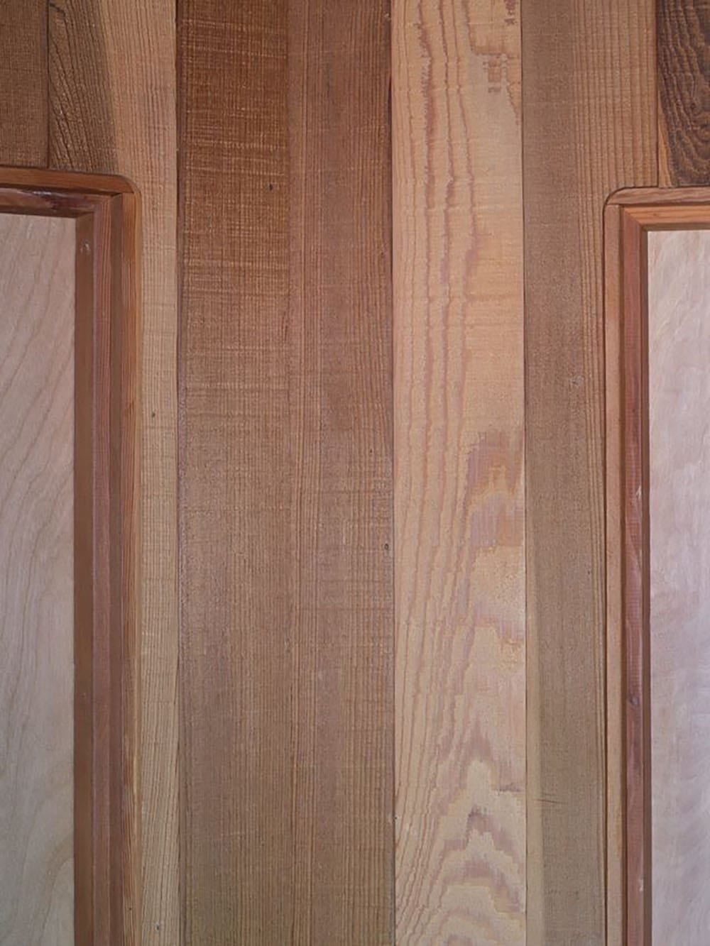 Detail of vertical cedar wall paneling with varied wood grain tones