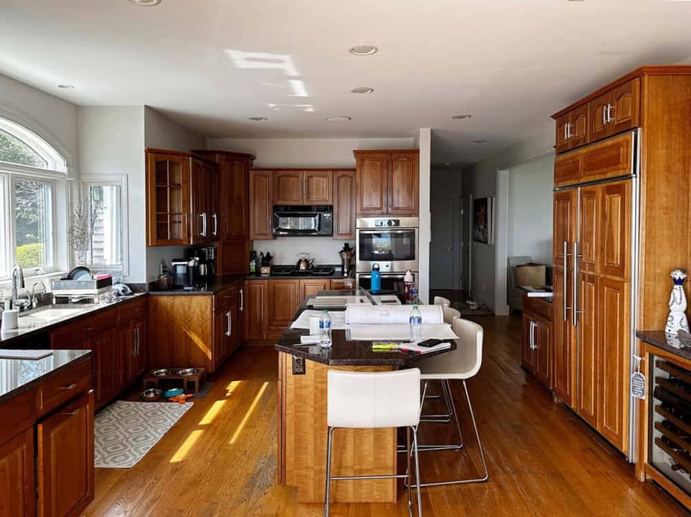 Kitchen with dark wood cabinets and black granite countertops before renovation