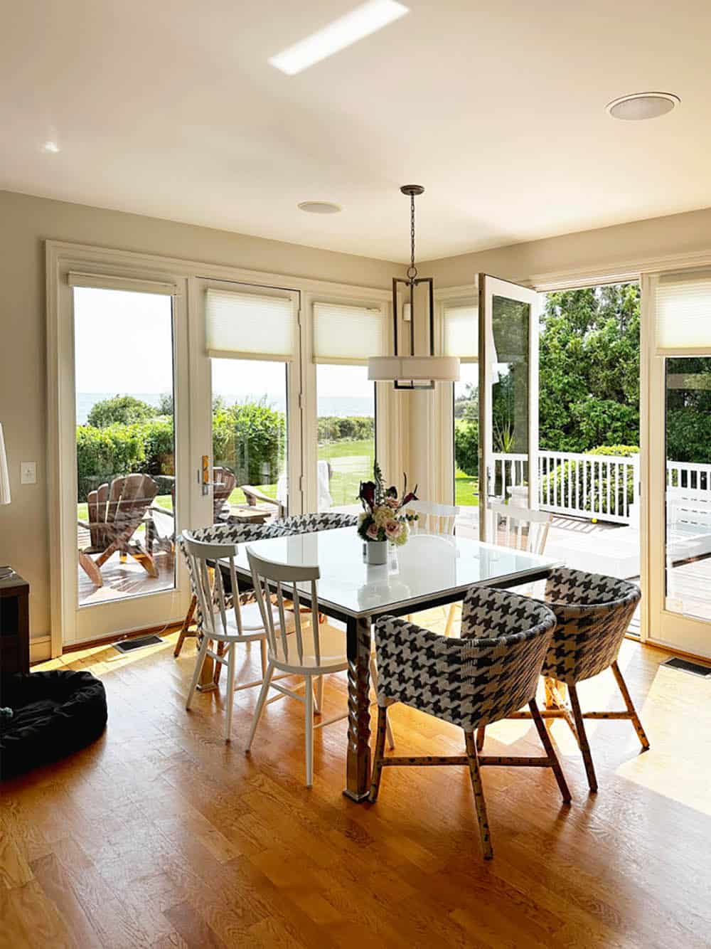 Dining area with white doors opening to ocean view before renovation