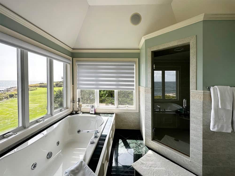 Primary bathroom with soaking tub and ocean views before renovation
