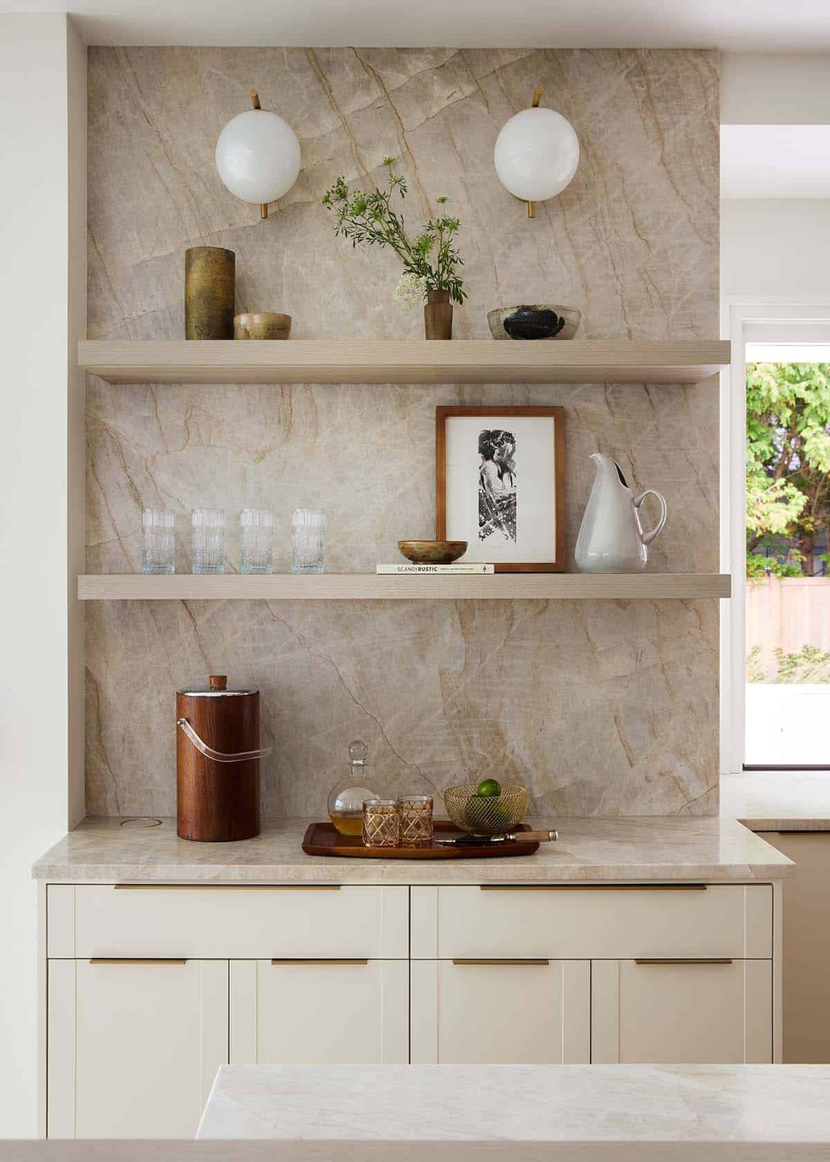 Kitchen open shelving with marble backsplash and brass sconces