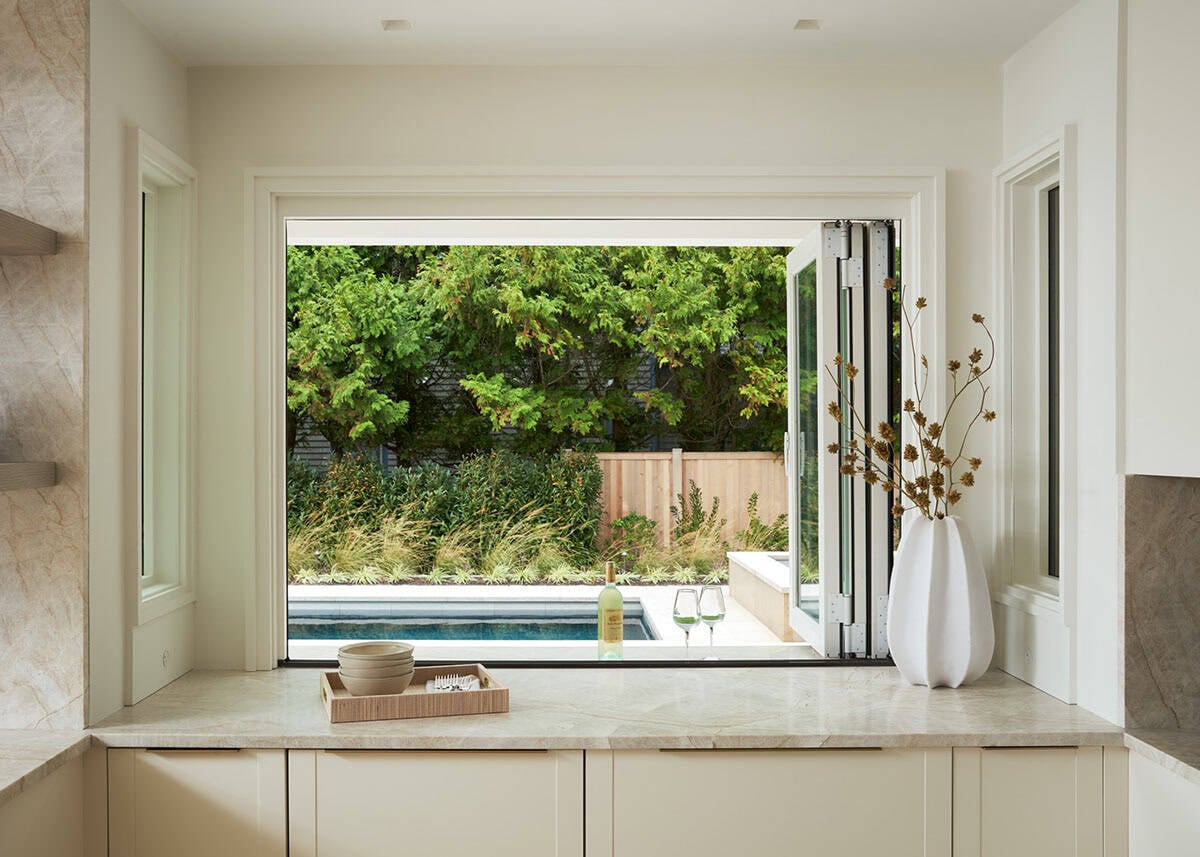 Pass-through window connecting kitchen to outdoor pool area