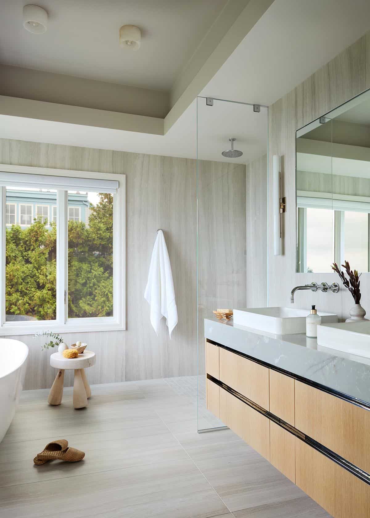 Primary bathroom with glass shower and floating wood vanity