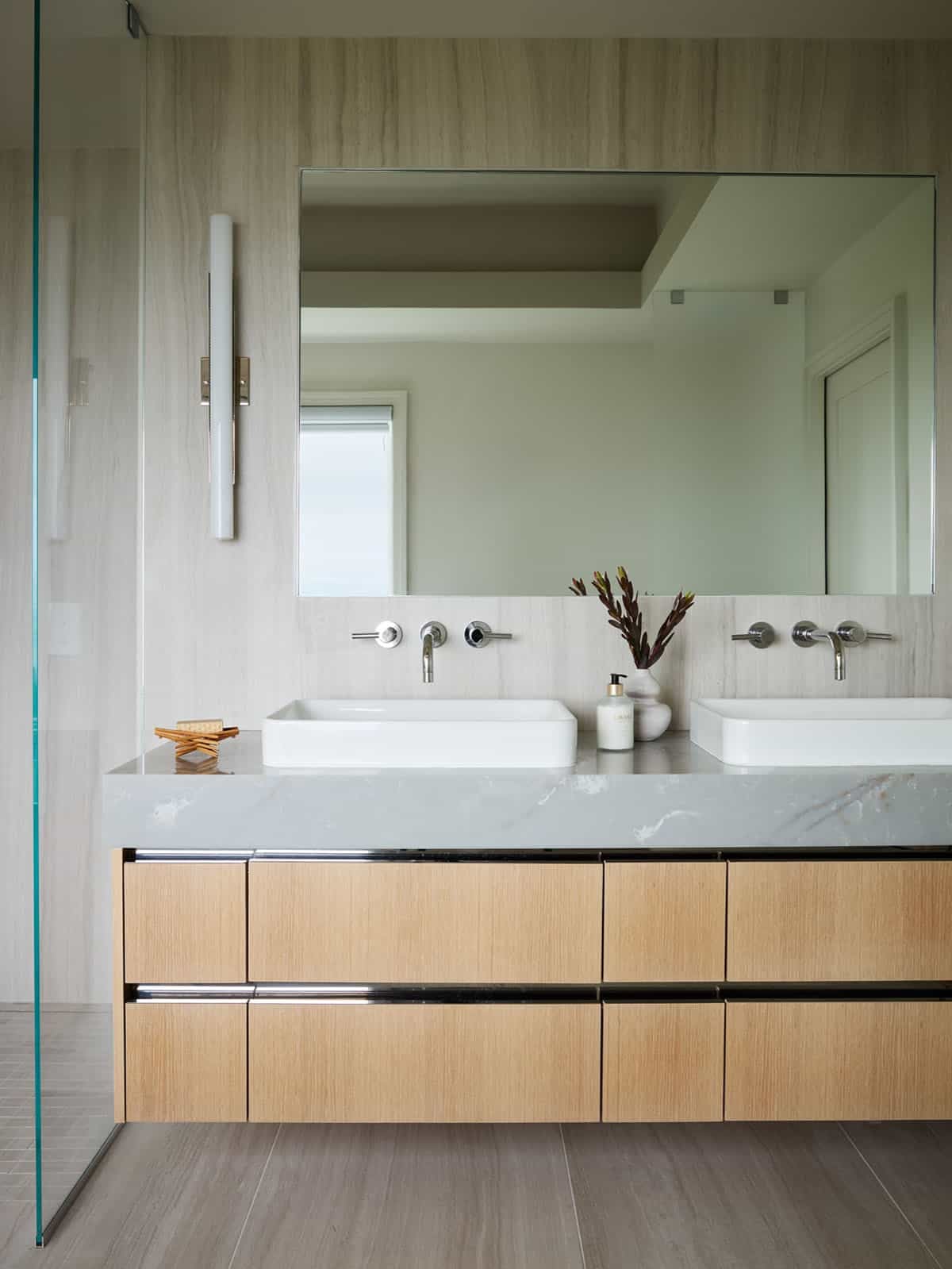 Double vanity detail with vessel sinks and wood-grain tile walls