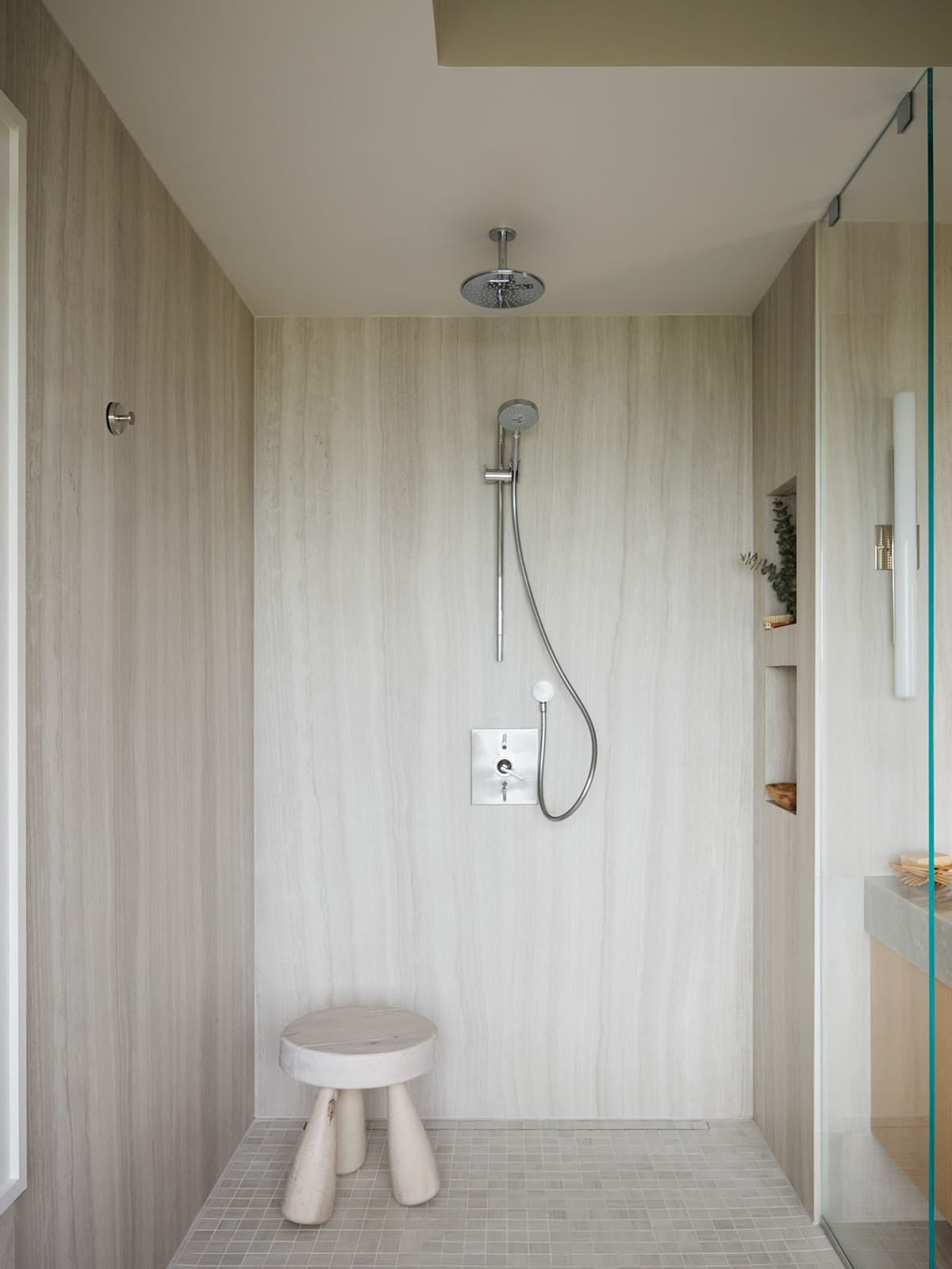 Walk-in shower with rain showerhead and wood stool