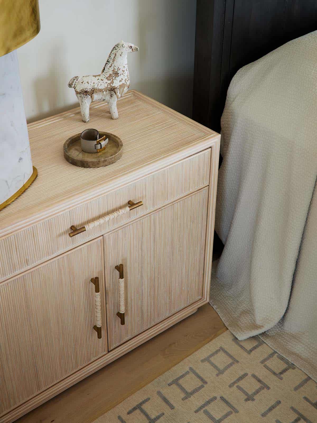 Nightstand detail with rattan hardware and carved horse figurine