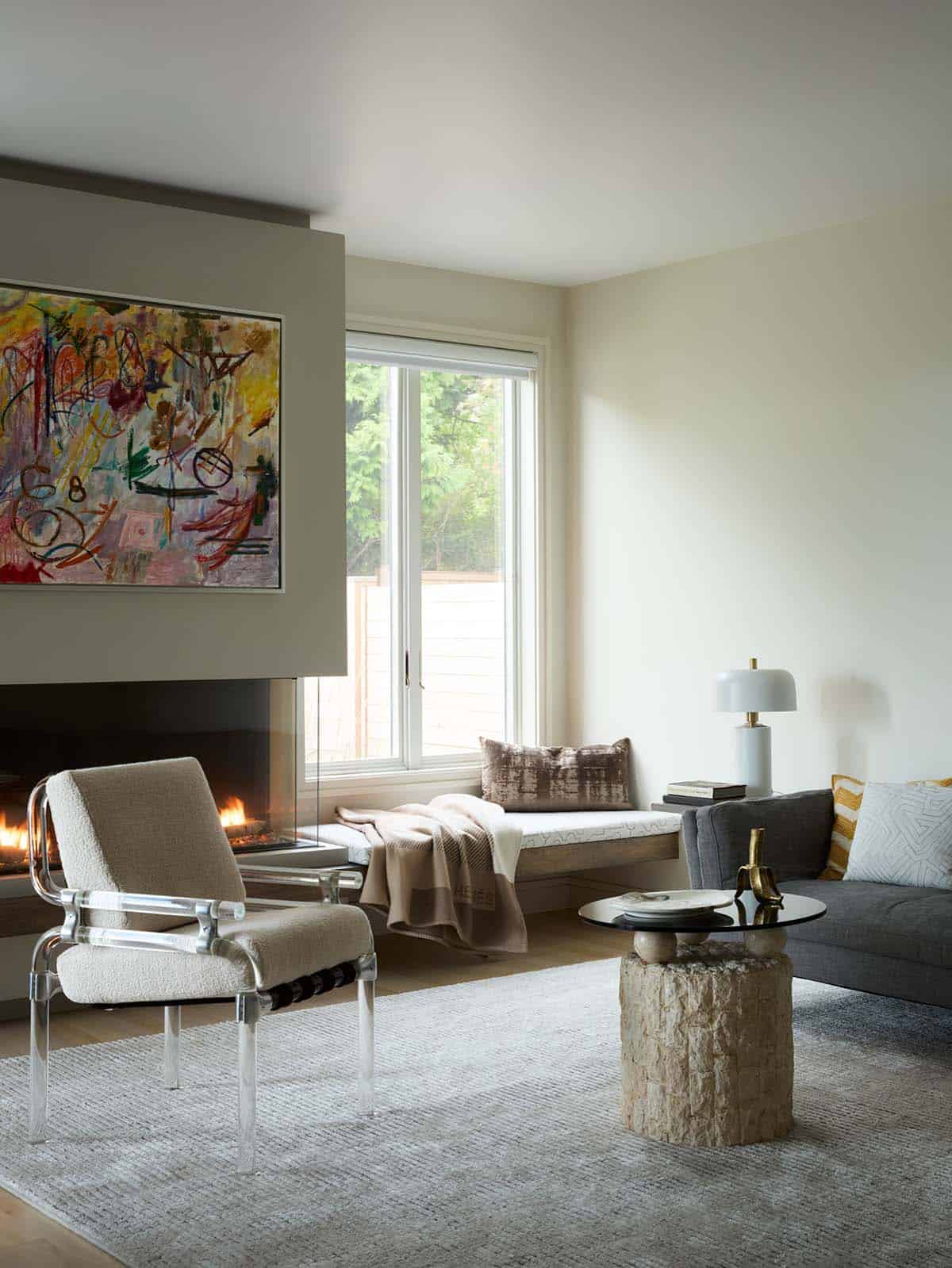 Living room fireplace with colorful abstract art and lucite chair