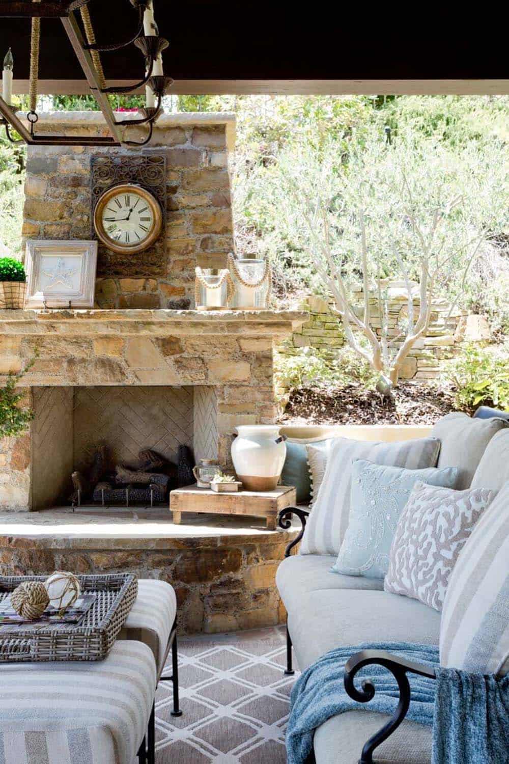 Stone fireplace with vintage clock on a coastal-inspired covered patio