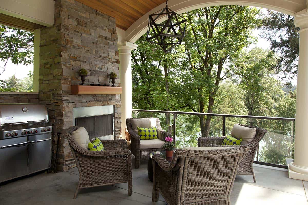 Stacked stone fireplace and outdoor kitchen on a covered riverfront porch