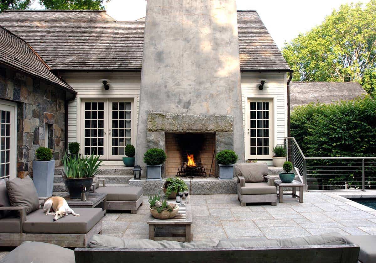 Tall stucco fireplace with stone hearth on a poolside patio
