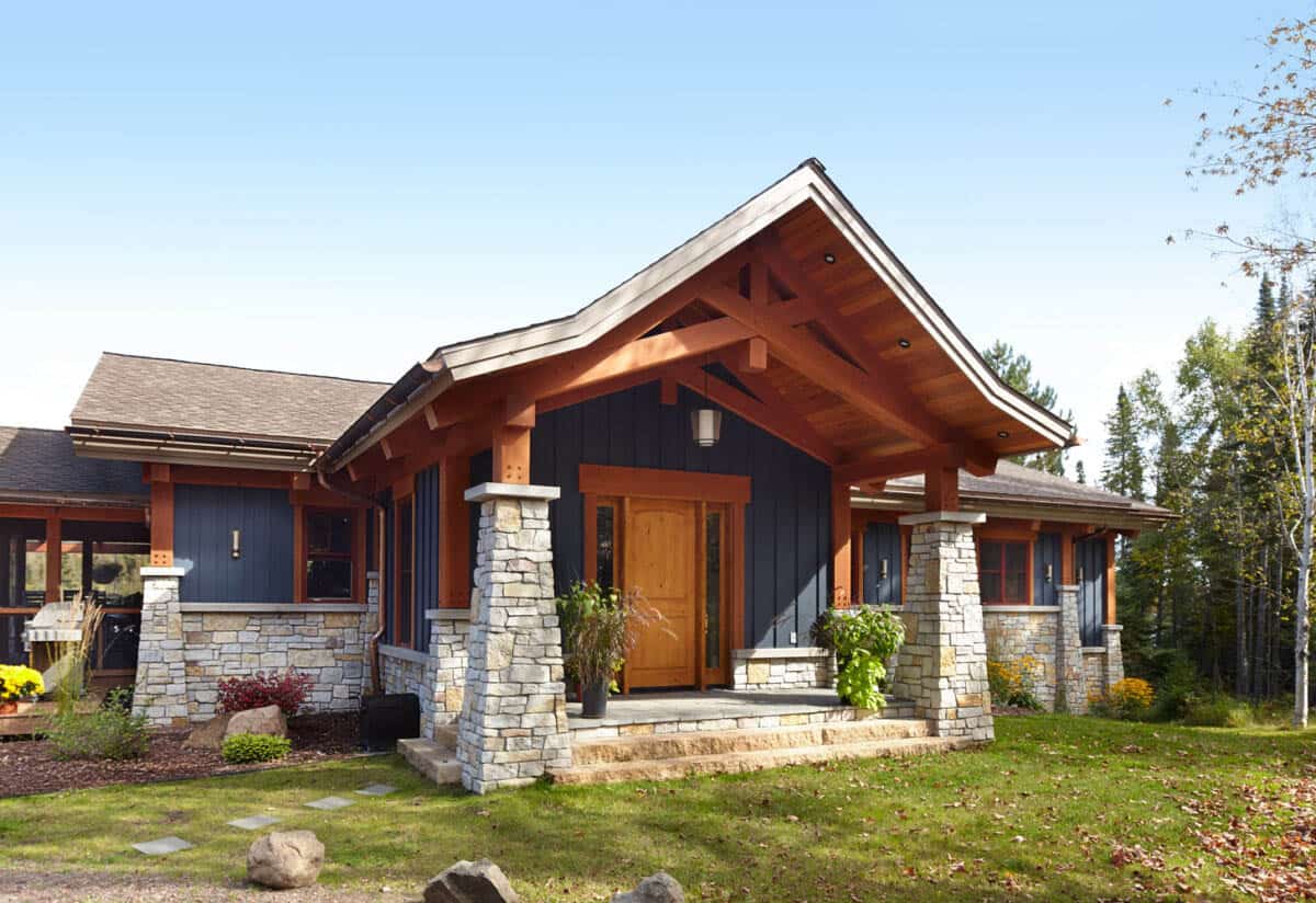 Gabled timber-frame entry with stone columns and wood front door