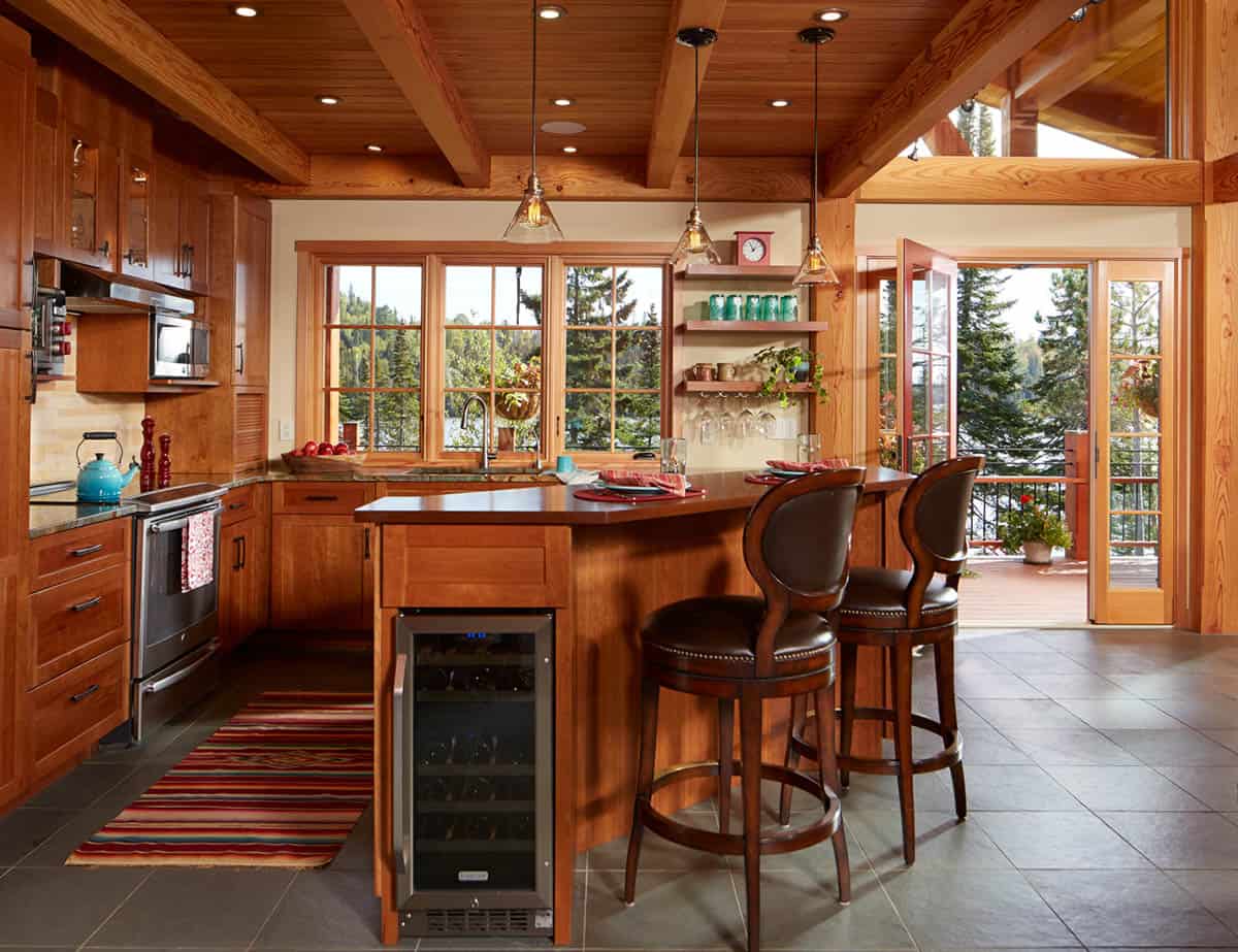 Kitchen island with wine fridge and leather bar stools overlooking deck