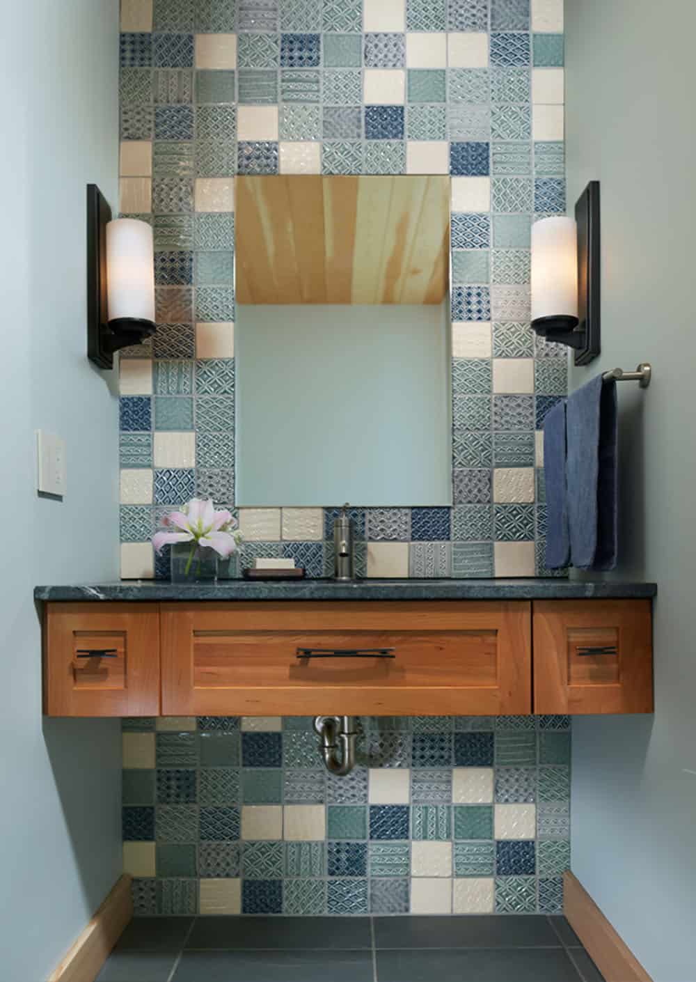 Powder room with mosaic tile wall and floating wood vanity