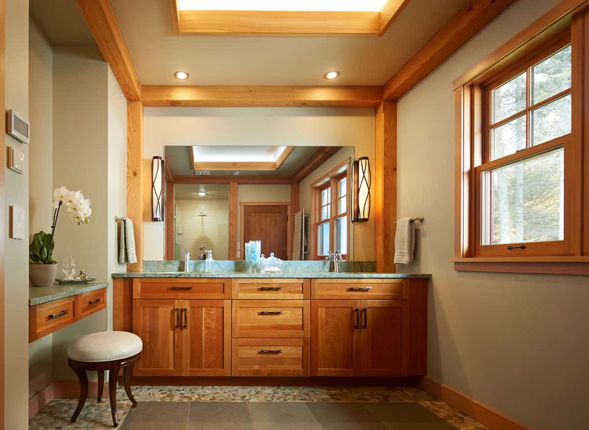 Primary bathroom with double vanity, green countertop, and skylight