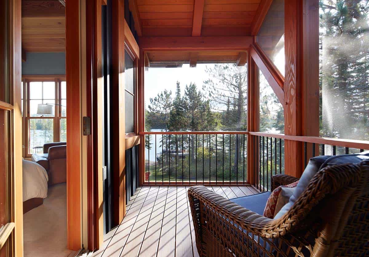 Screened porch off bedroom with wicker chair and lake view