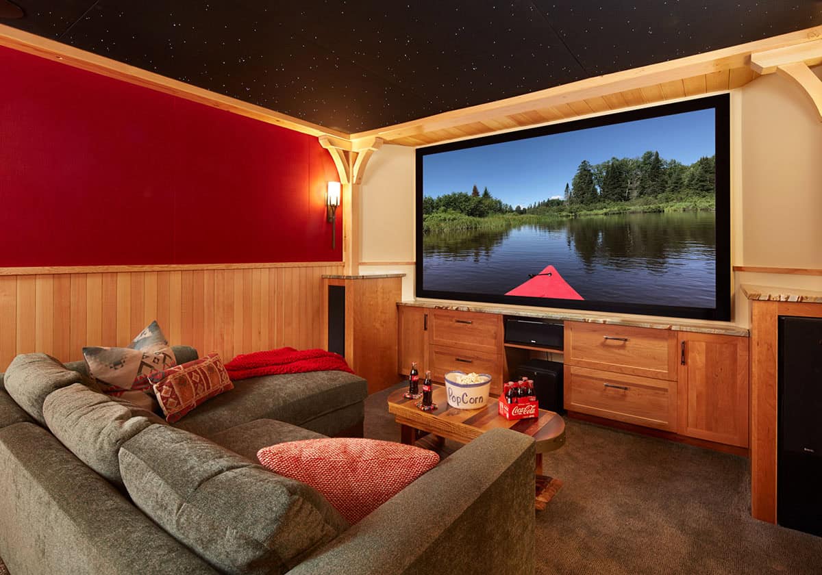 Home theater with red wall, starlit ceiling, and large screen