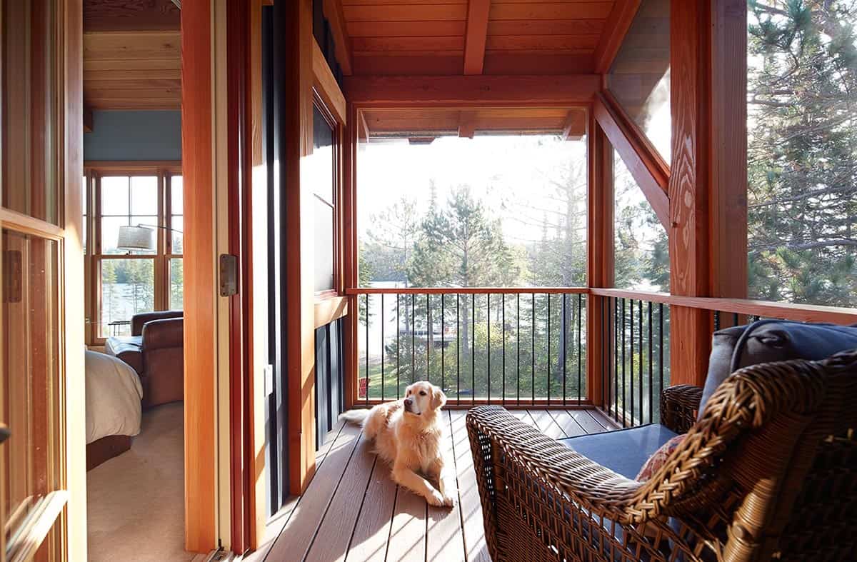 Golden retriever resting on screened porch with lake view