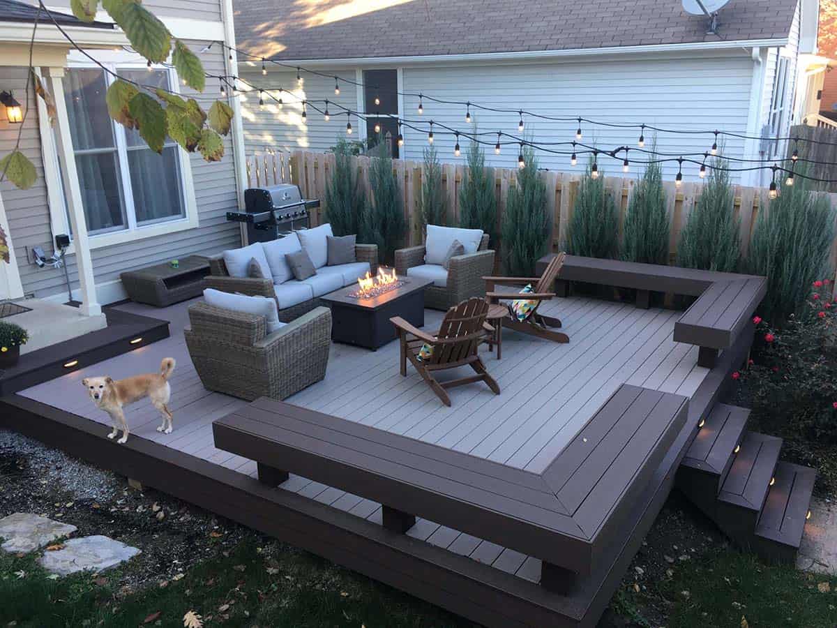 TimberTech composite deck in Indiana with string lights, fire table, and dog on deck