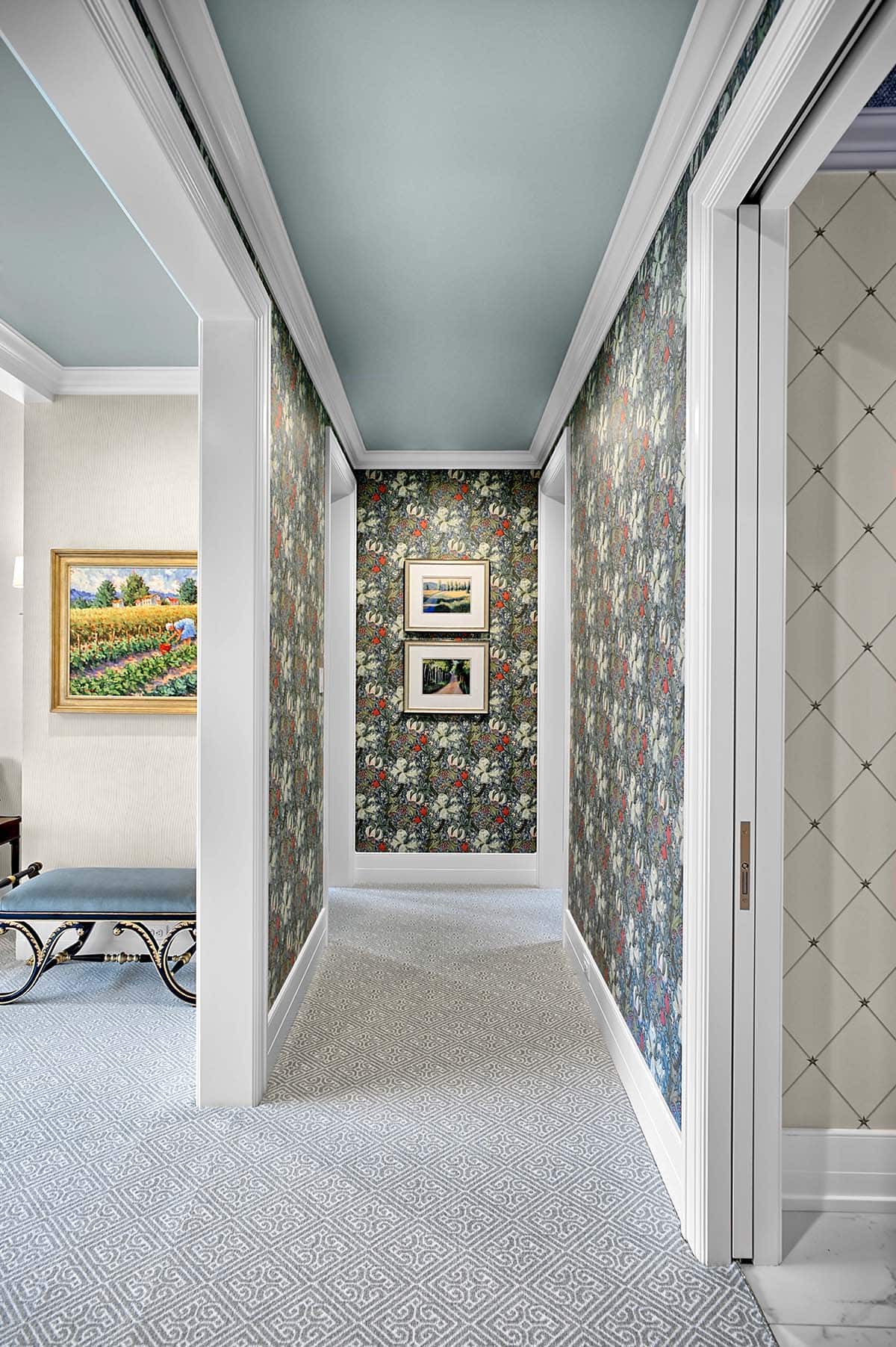 Hallway lined with botanical wallpaper and a soft blue ceiling