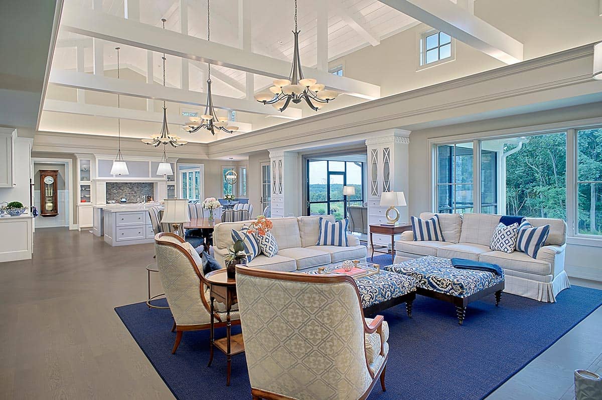 Open-concept living area with vaulted beamed ceiling and blue-and-white furnishings