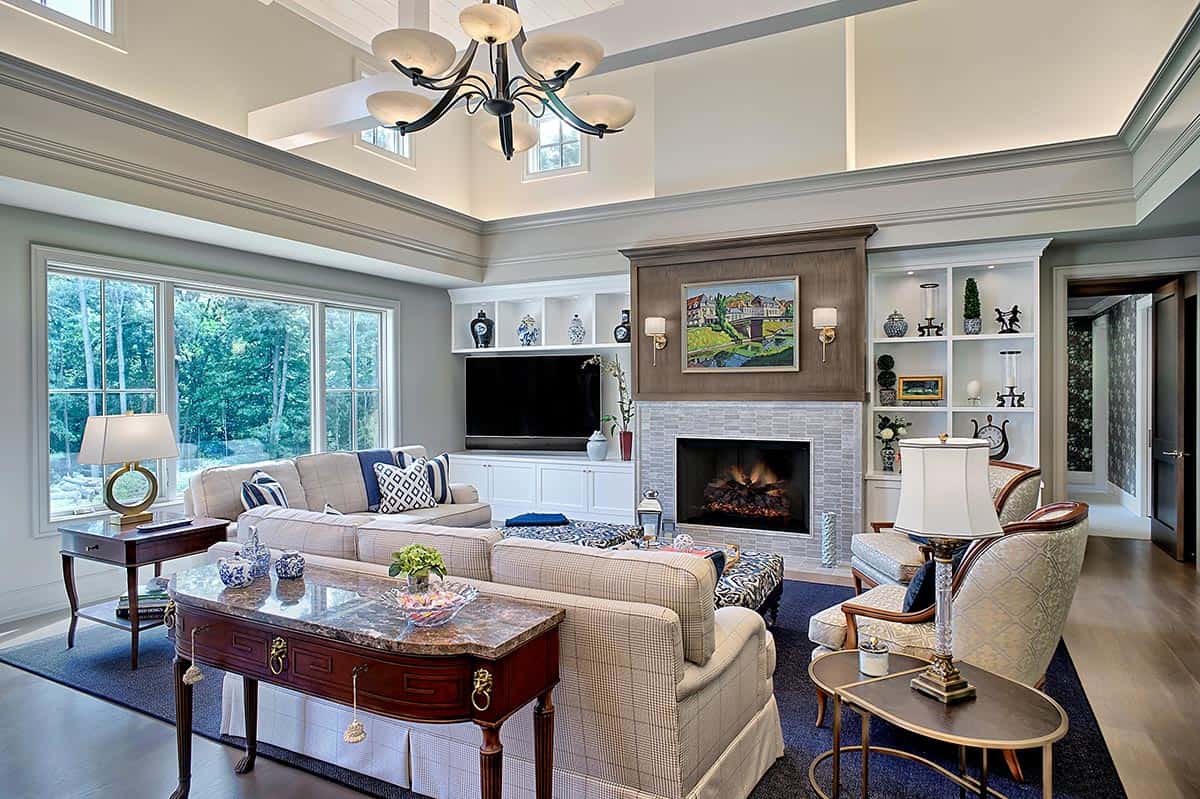 Family room with a stone fireplace, built-in shelving, and plaid sectional sofa