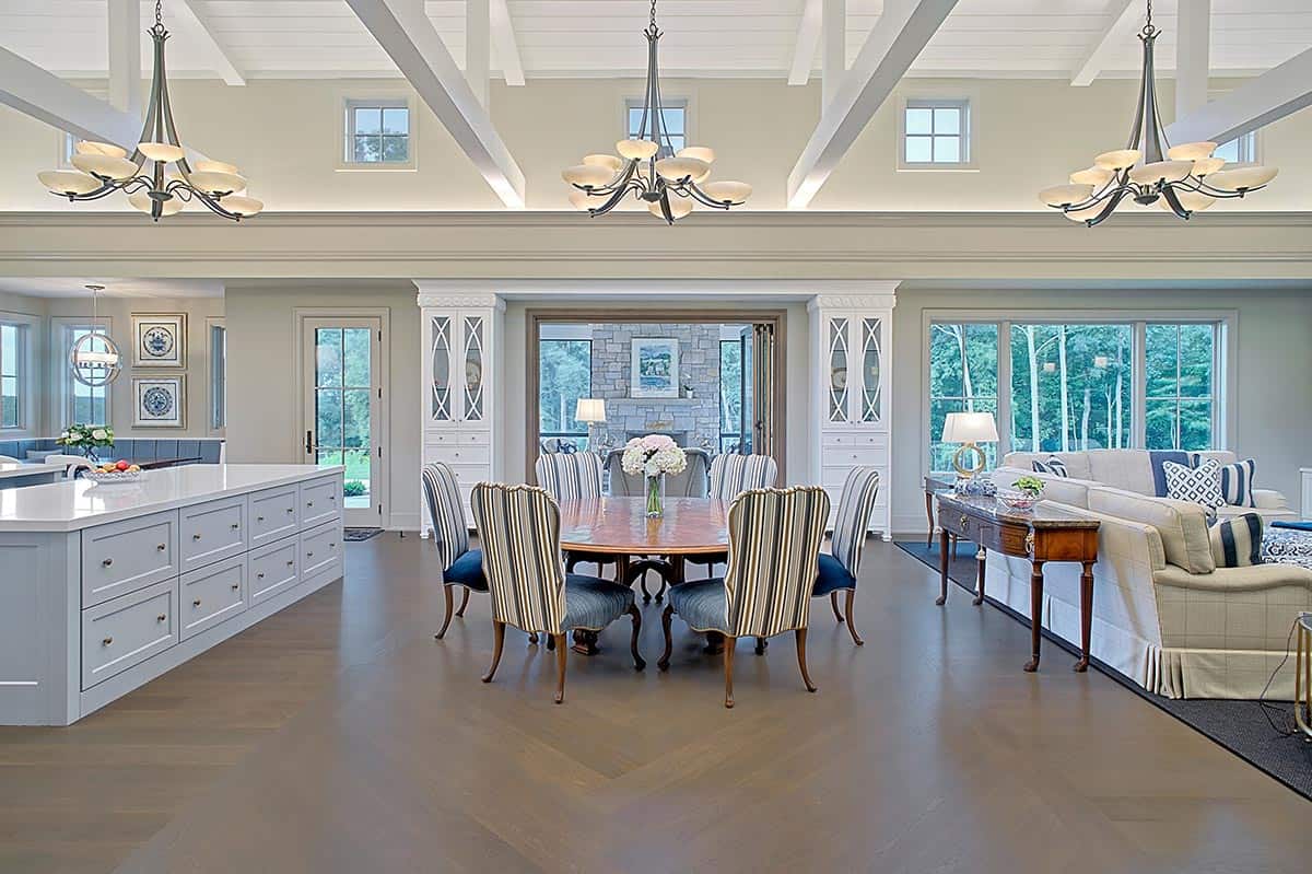 Dining area with round wood table, striped chairs, and chevron hardwood floors