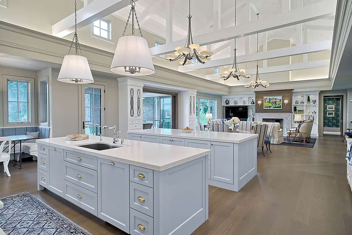 Kitchen with dual gray islands and pendant lighting beneath a beamed ceiling