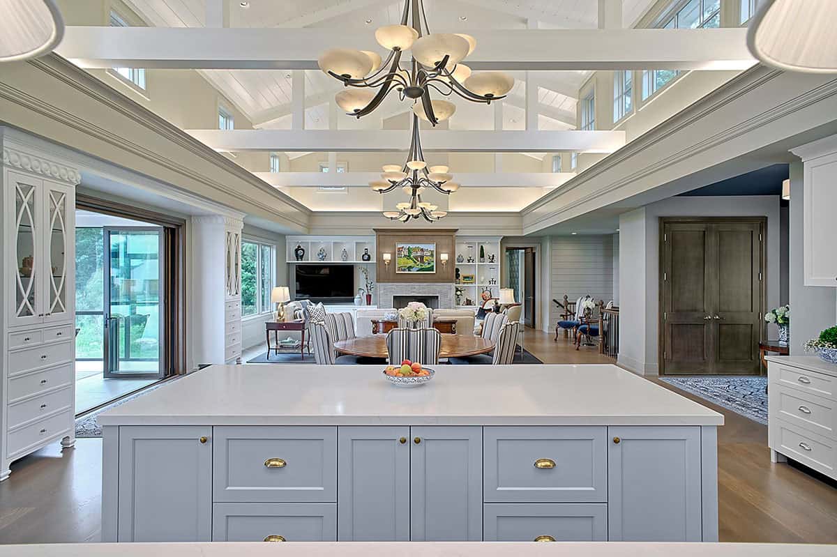 Kitchen island with chandeliers overlooking the open living and dining areas