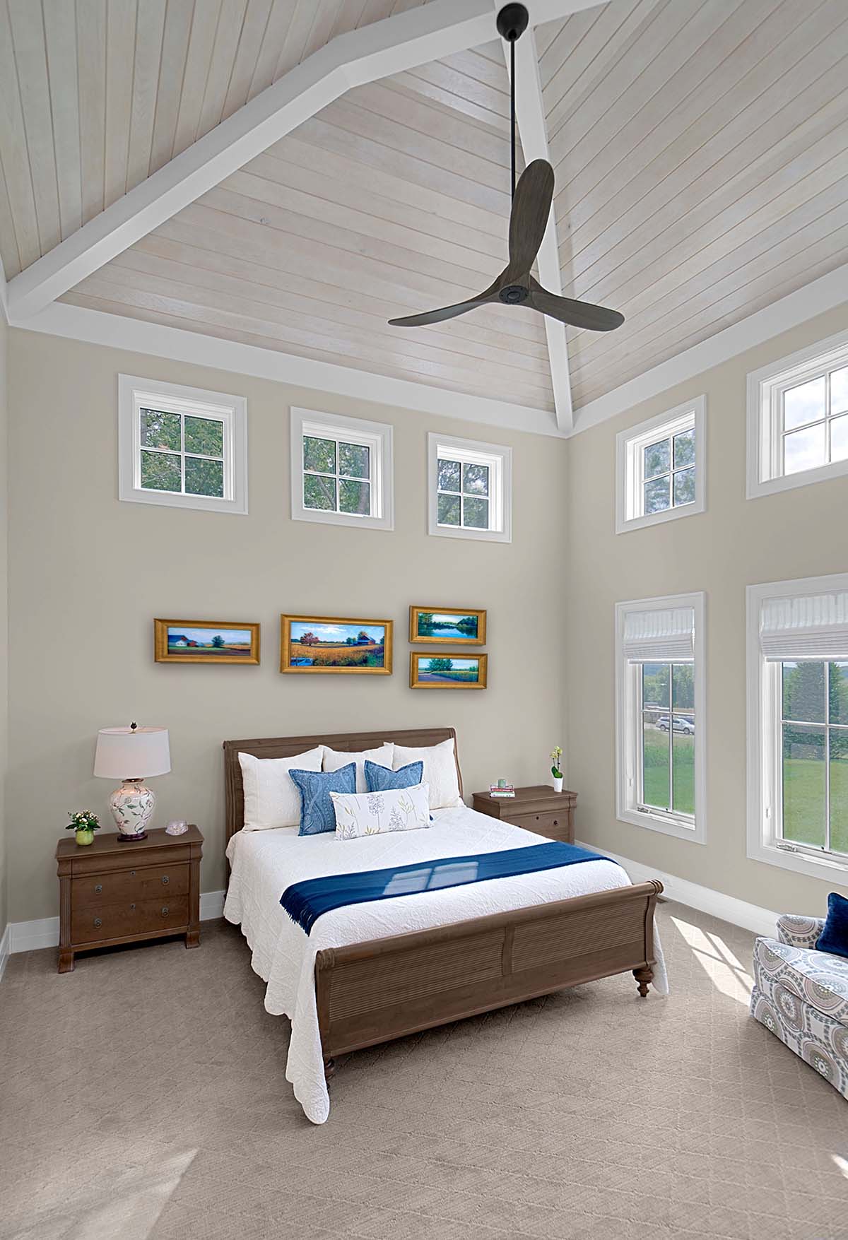 Guest bedroom with vaulted shiplap ceiling, ceiling fan, and gallery wall art