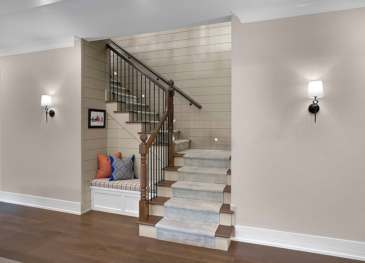 Staircase nook with a built-in bench and wrought iron railing
