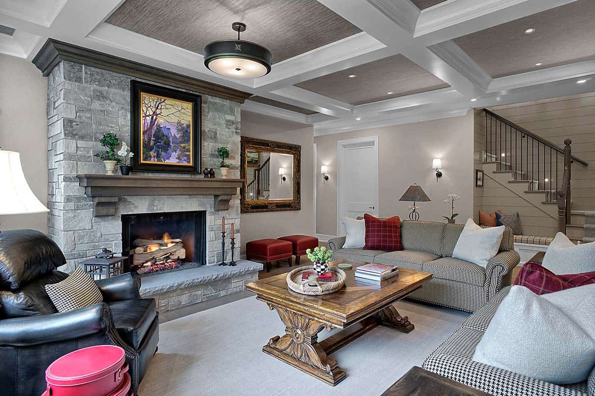Basement lounge with stone fireplace and houndstooth-upholstered sofas