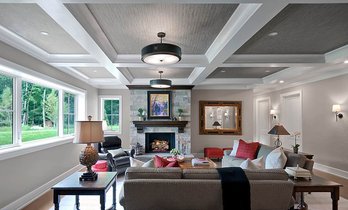 Basement family room with coffered ceiling and yard views through large windows
