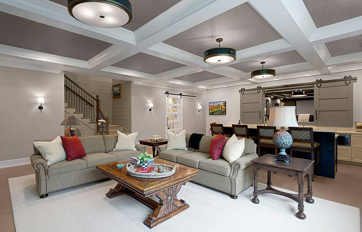 Basement lounge with sliding barn doors leading to a wet bar