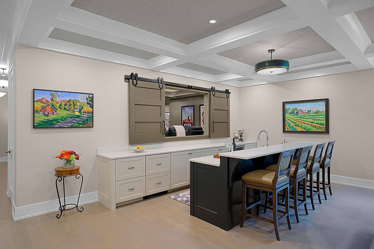 Basement wet bar with black cabinetry and leather counter stools