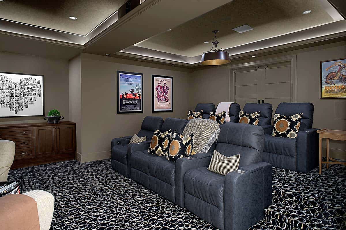 Home theater with tiered navy recliners and vintage western movie posters