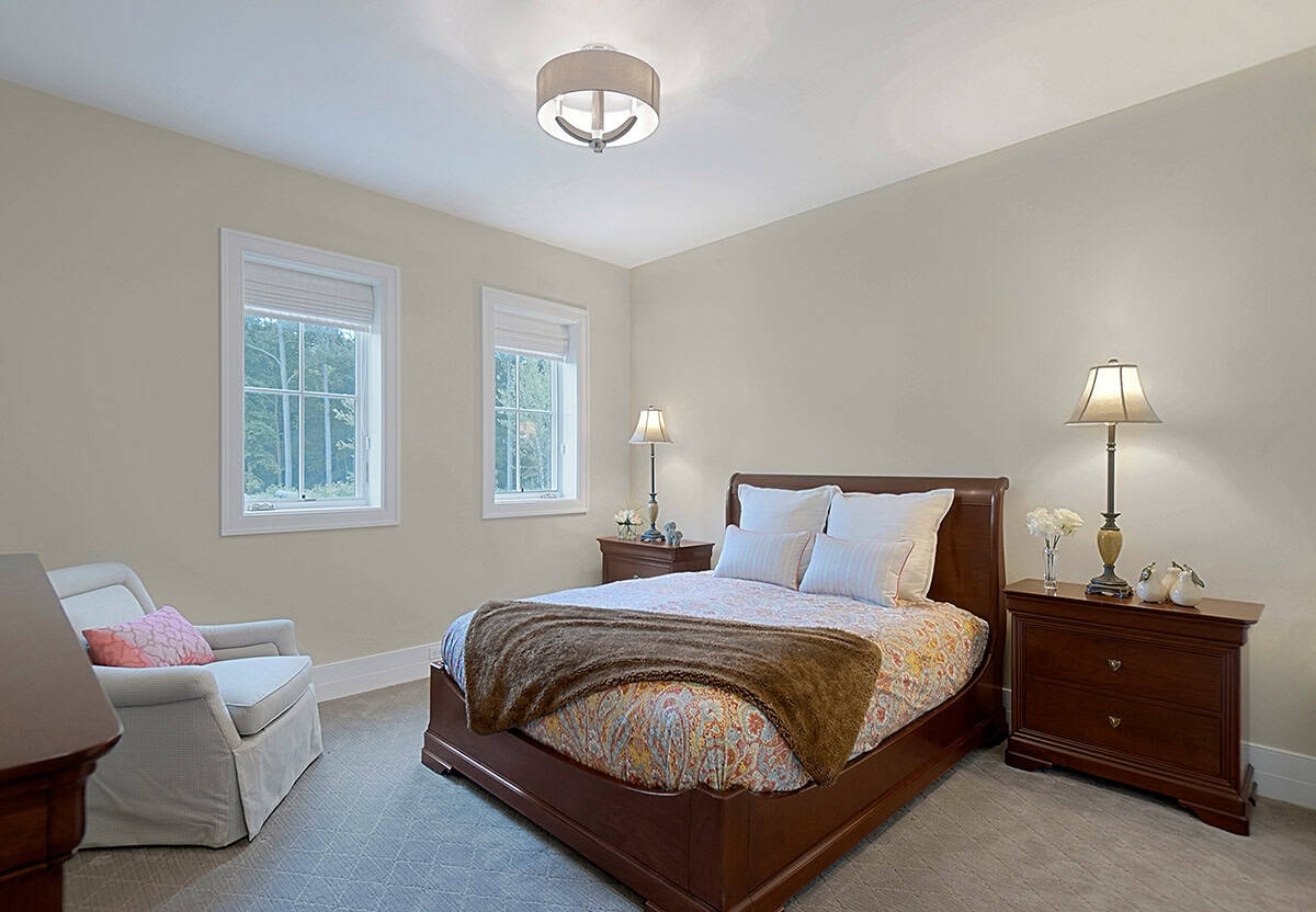 Guest bedroom with a wood sleigh bed and neutral bedding
