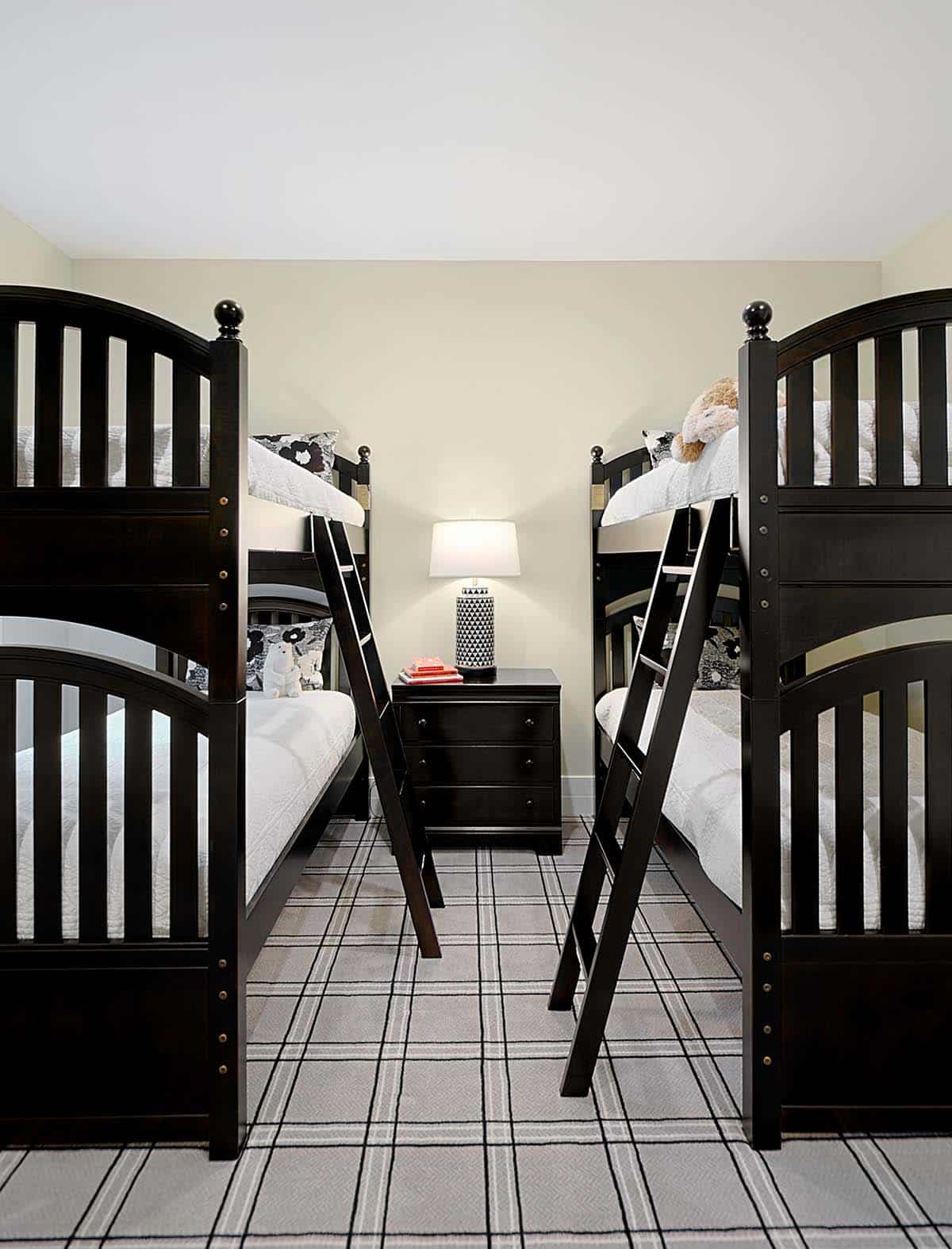 Kids' bunk room with matching dark wood bunk beds and plaid carpet
