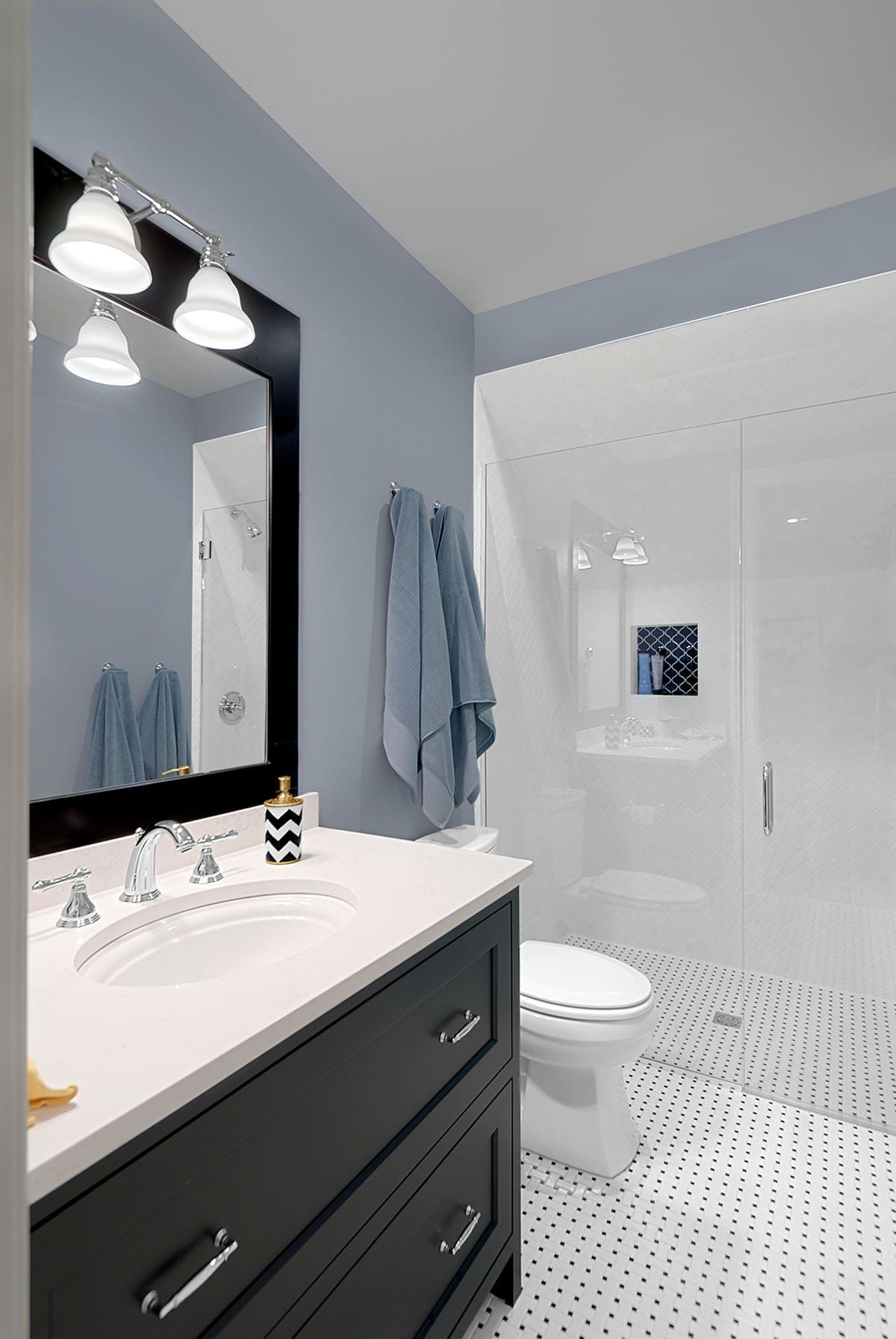 Bathroom with a black vanity, blue walls, and glass-enclosed shower