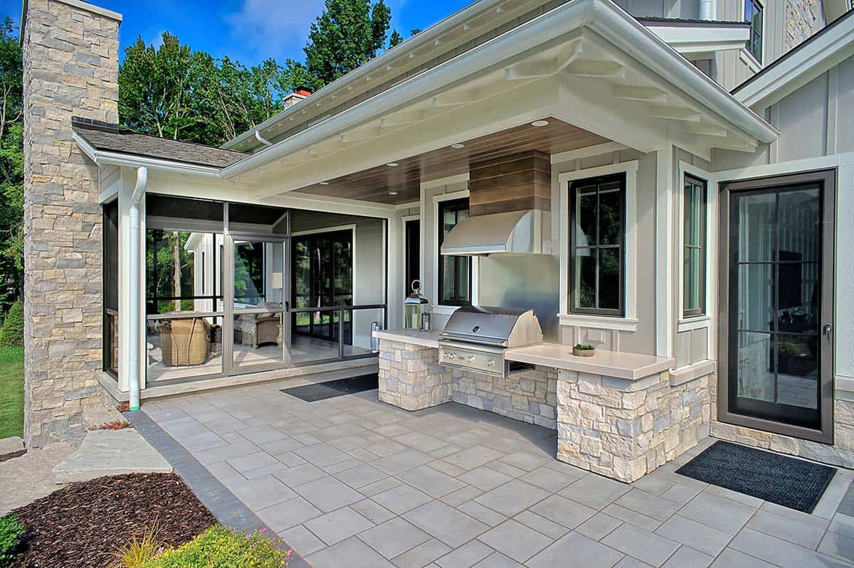 Outdoor kitchen with a stainless grill and stone counter off the screened porch