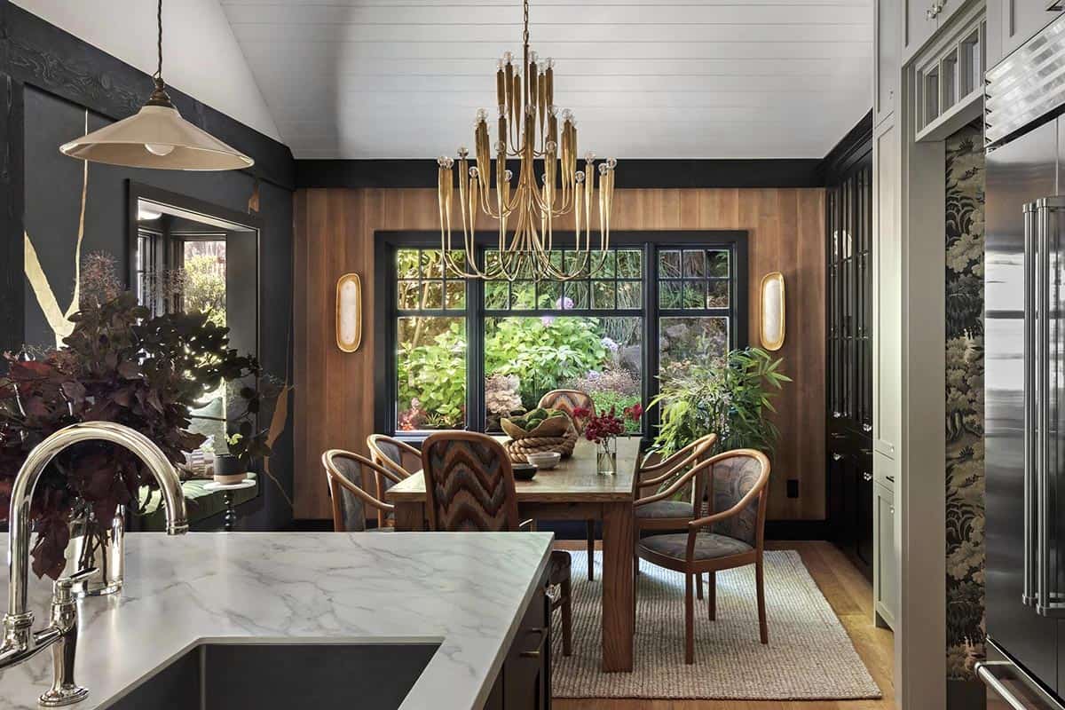 Kitchen and dining nook with brass chandelier, wood paneling, and garden view window