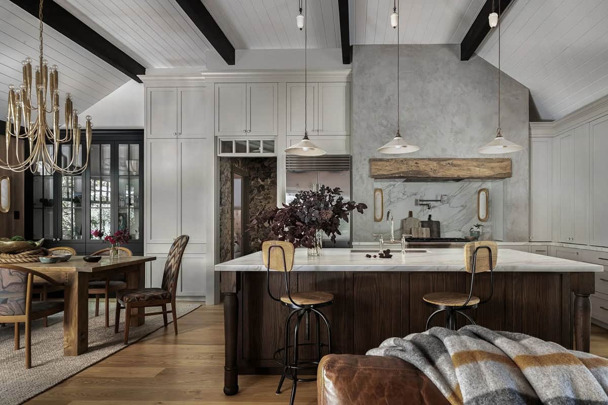 Kitchen with white cabinetry, marble backsplash, dark wood island, and vintage pendant lights