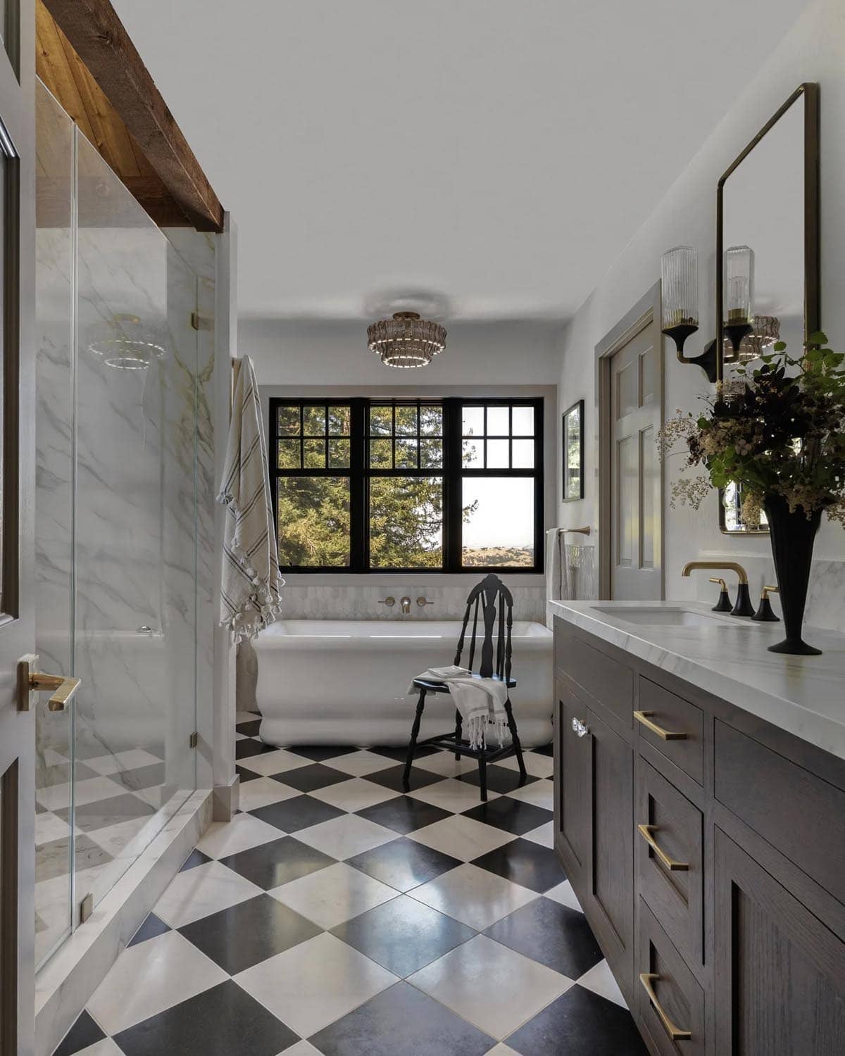 Primary bathroom with black-and-white checkered floor, freestanding tub, and dark wood vanity