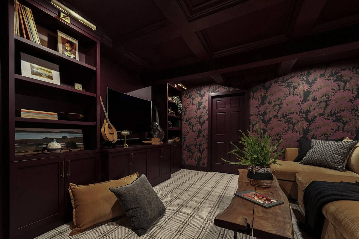 Moody den with burgundy walls, floral wallpaper, built-in bookshelves, and live-edge coffee table