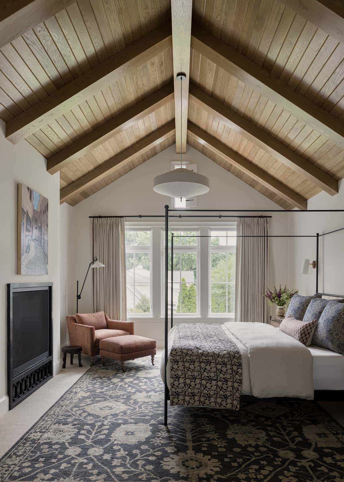 Primary bedroom with vaulted wood ceiling, canopy bed, and floral rug