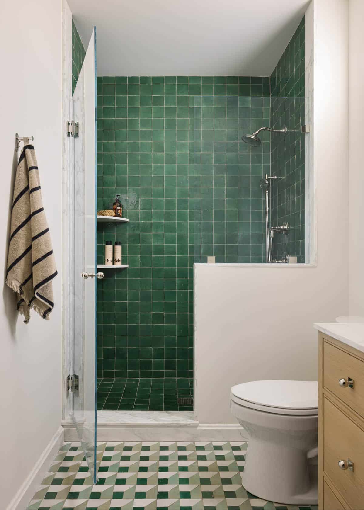 Bathroom with emerald green zellige shower tile and geometric green floor tile