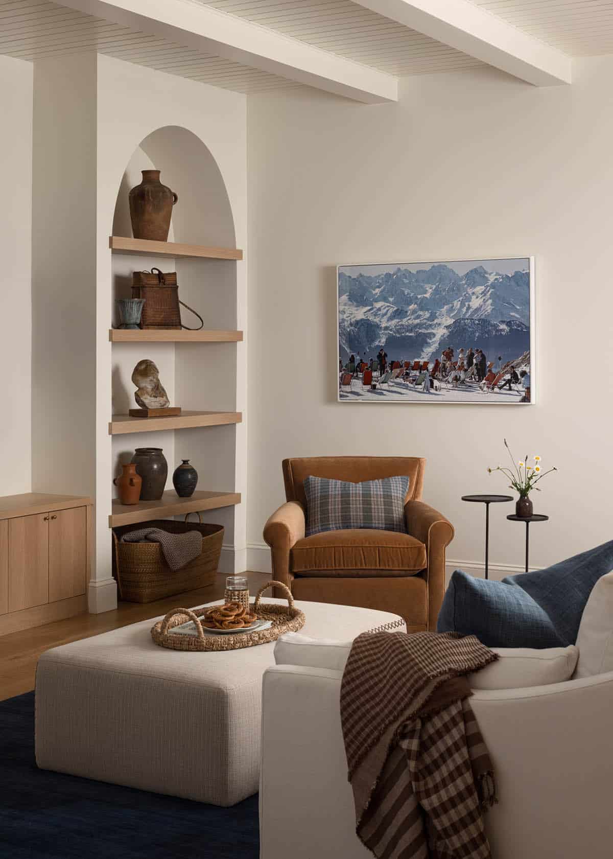 Cozy sitting area with arched built-in shelving and mountain ski photograph