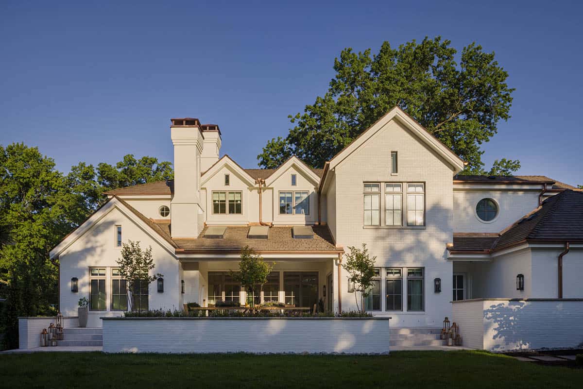 Rear exterior of white brick home with multiple gables and covered patio