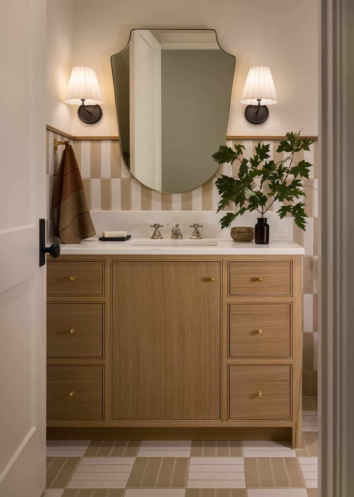 Bathroom vanity with striped tile backsplash and organic-shaped mirror