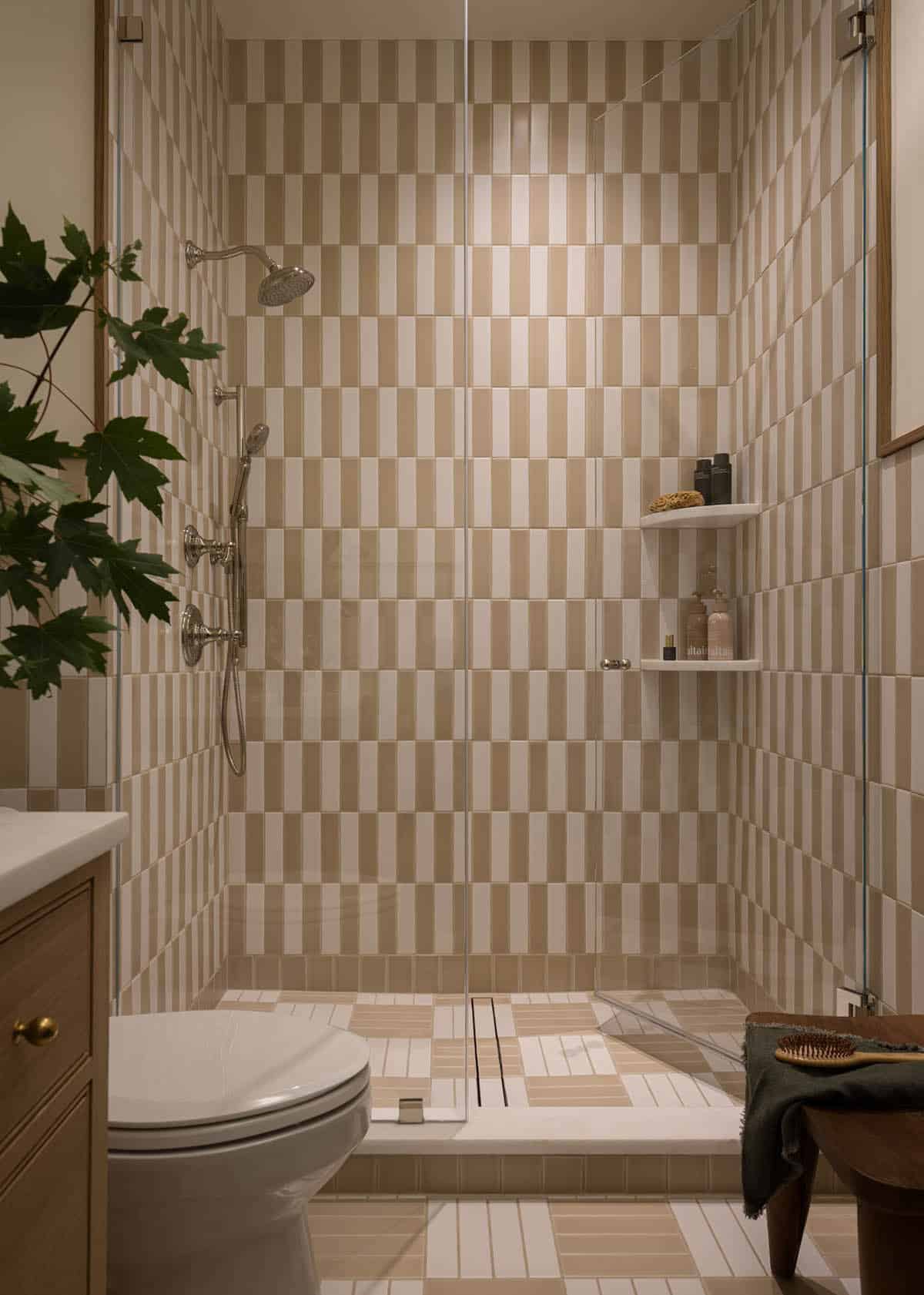 Shower with tan and cream checkered tile pattern and toilet